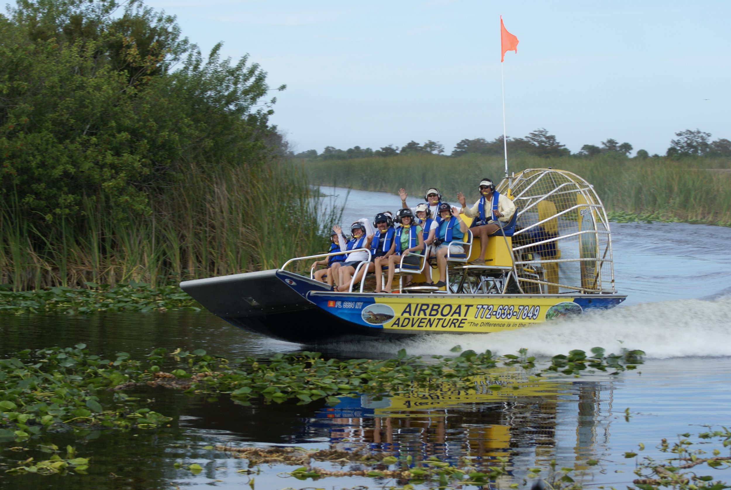 People enjoying an airboat tour on a sunny day.