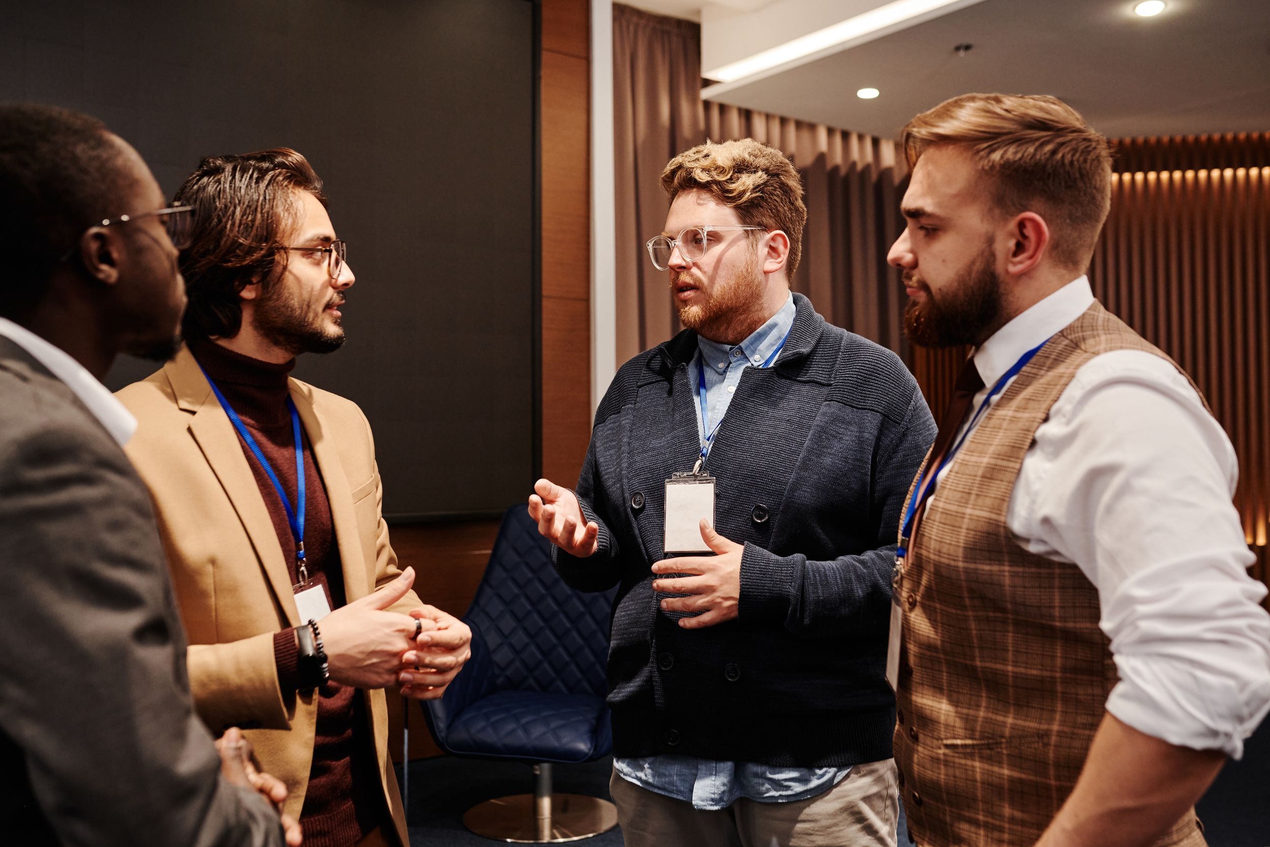 Group of people in business attire chatting at an event.