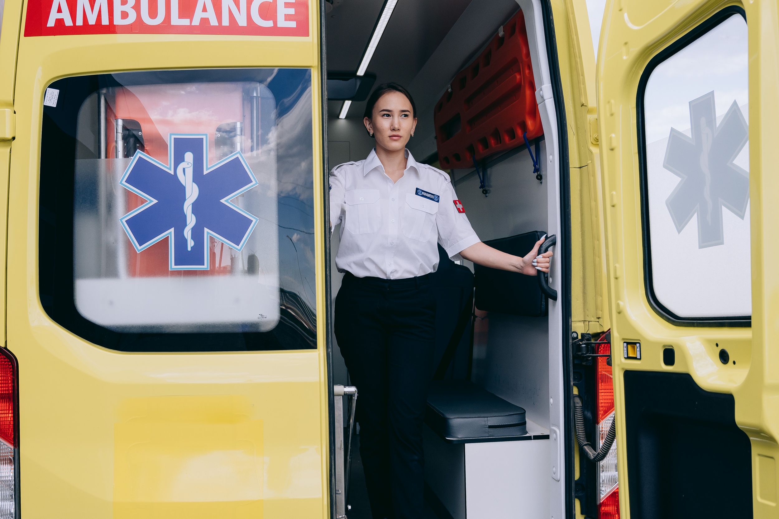 Paramedic standing in the back of an open ambulance.